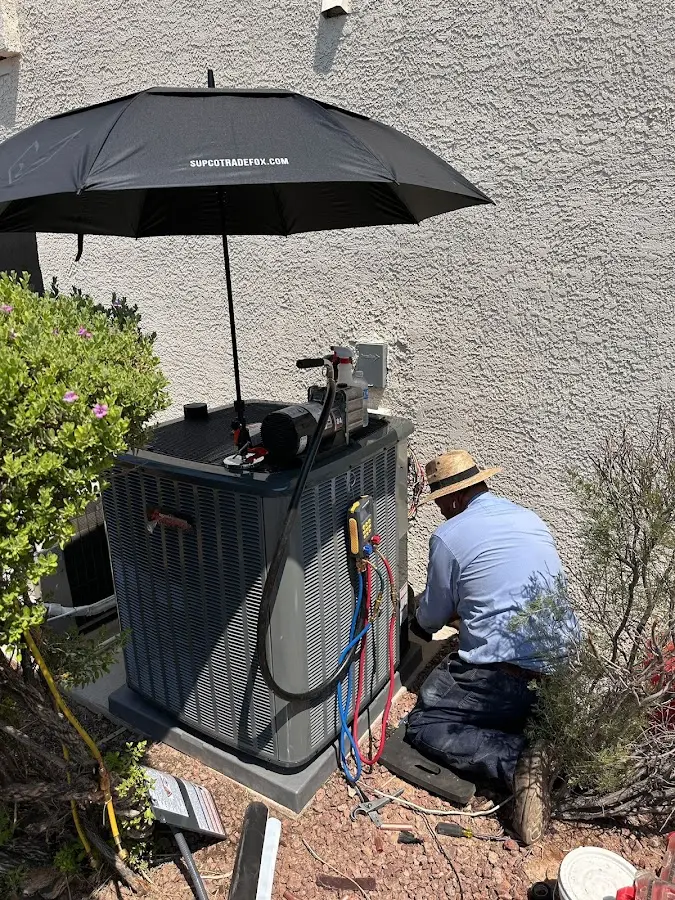 HVAC technician performing outdoor AC maintenance in Hales Corners